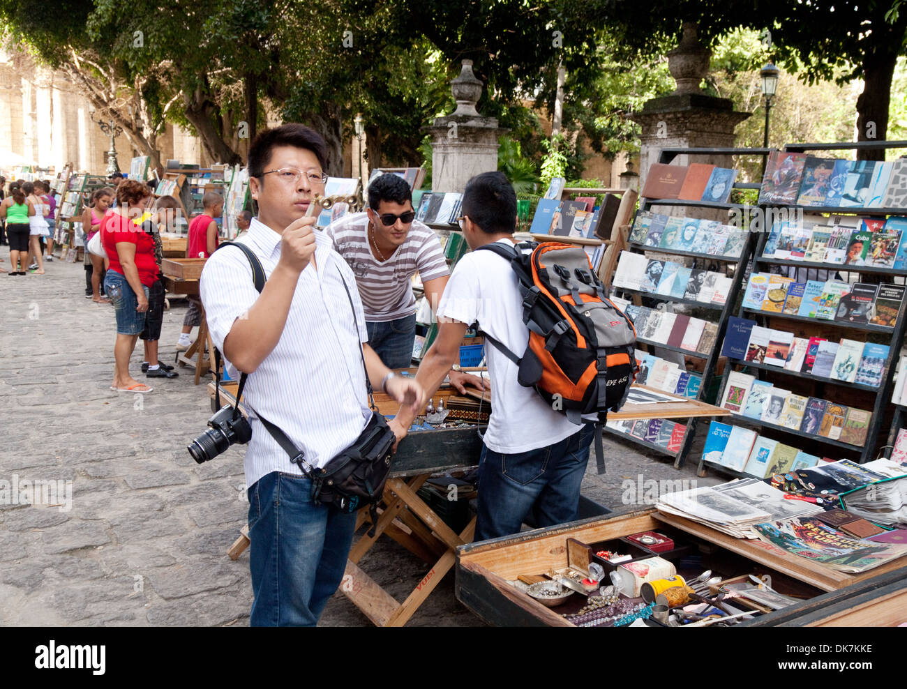 Chinese tourists in Cuba looking at books in the market, Plaza de Armas square, Havana Cuba, Caribbean Stock Photo