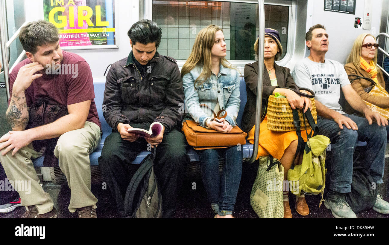 diverse grouping of random American faces including saucy twenty something gathered together on New York Subway train Manhattan Stock Photo