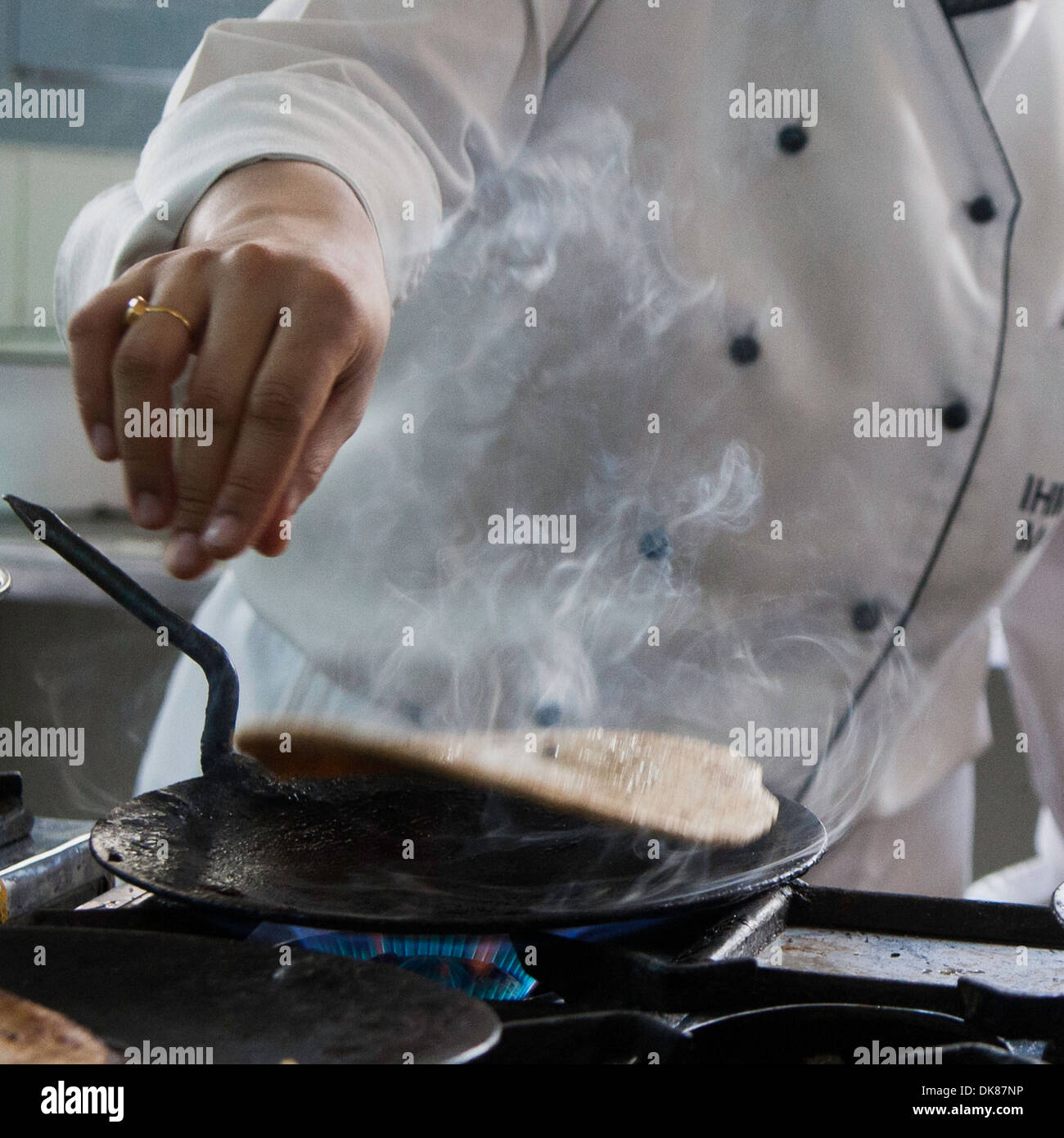chef flipping hot flatbread, castiron cookware Stock Photo Alamy
