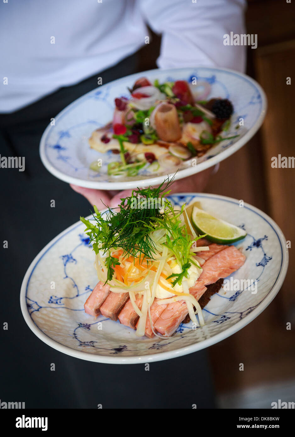 Hand holding a two plates of smorrebrod at Restaurant Schonnemann Serving traditional Danish food, Copenhagen, Denmark Stock Photo