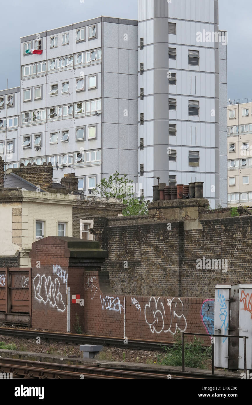 An inner London tower block with graffiti in the foreground and an Italian flag hangs from a top window Stock Photo
