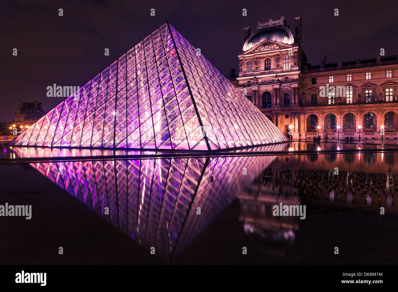 Night scene of the Pyramid entrance of Louvre Museum, Paris. Reflection in the pond Stock Photo