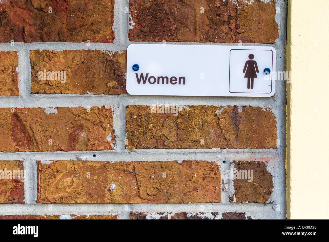 Sign on brick wall at entrance to Women's restroom. Stock Photo