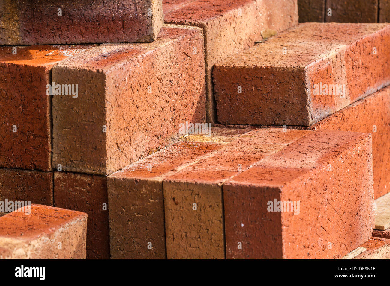 Stack of red bricks forms abstract geometric angular shapes Stock Photo