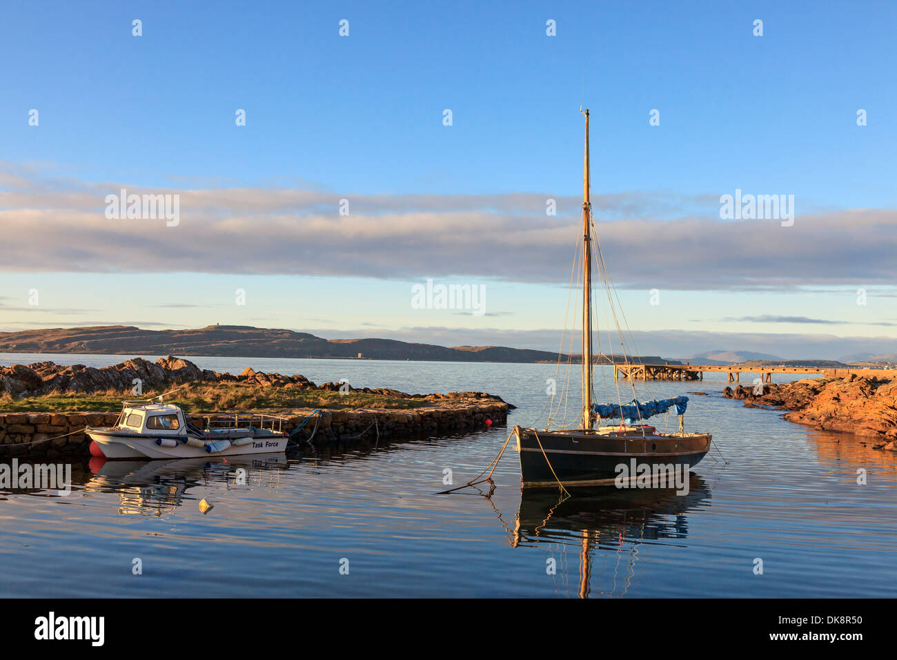 Portencross harbour at sunset, Ayrshire, Scotland, with a view north to the Island of Millport across the Firth of Clyde Stock Photo