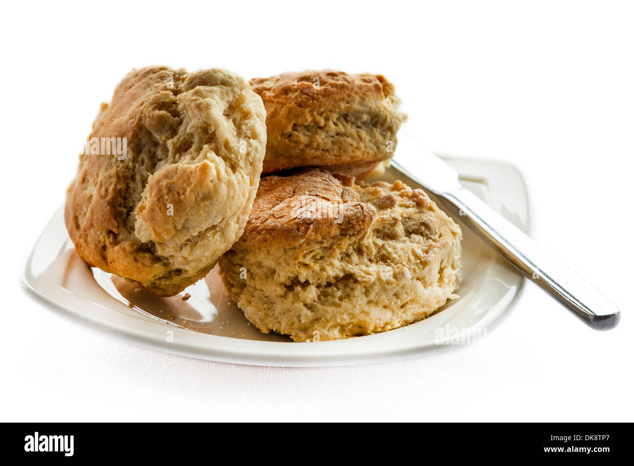 A plate with three homemade scones and a knife Stock Photo