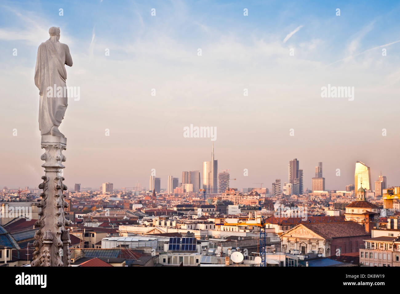 Milan, end of 2013 new panoramic skyline at sunset. One of the religious statues of Duomo cathedral faces north to the new build Stock Photo