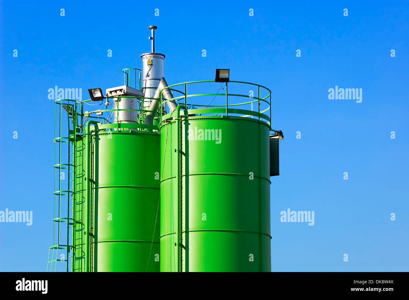 Two green silos against blue sky in a construction site Stock Photo - Alamy