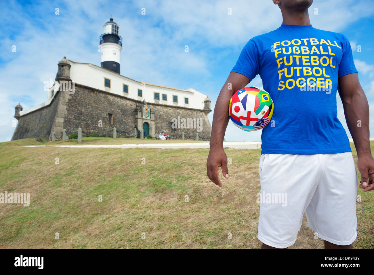 Brazilian soccer player stands with international football at the lighthouse in Salvador Brazil Stock Photo