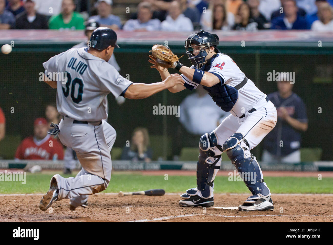 Aug. 22, 2011 - Cleveland, Ohio, U.S - Seattle catcher Miguel Olivo (30) slides in to home as Cleveland catcher Lou Marson (6) waits for the throw during the ninth inning.  Olivo was called safe as the Seattle Mariners defeated the Cleveland Indians 3-2 at Progressive Field in Cleveland, Ohio. (Credit Image: © Frank Jansky/Southcreek Global/ZUMAPRESS.com) Stock Photo