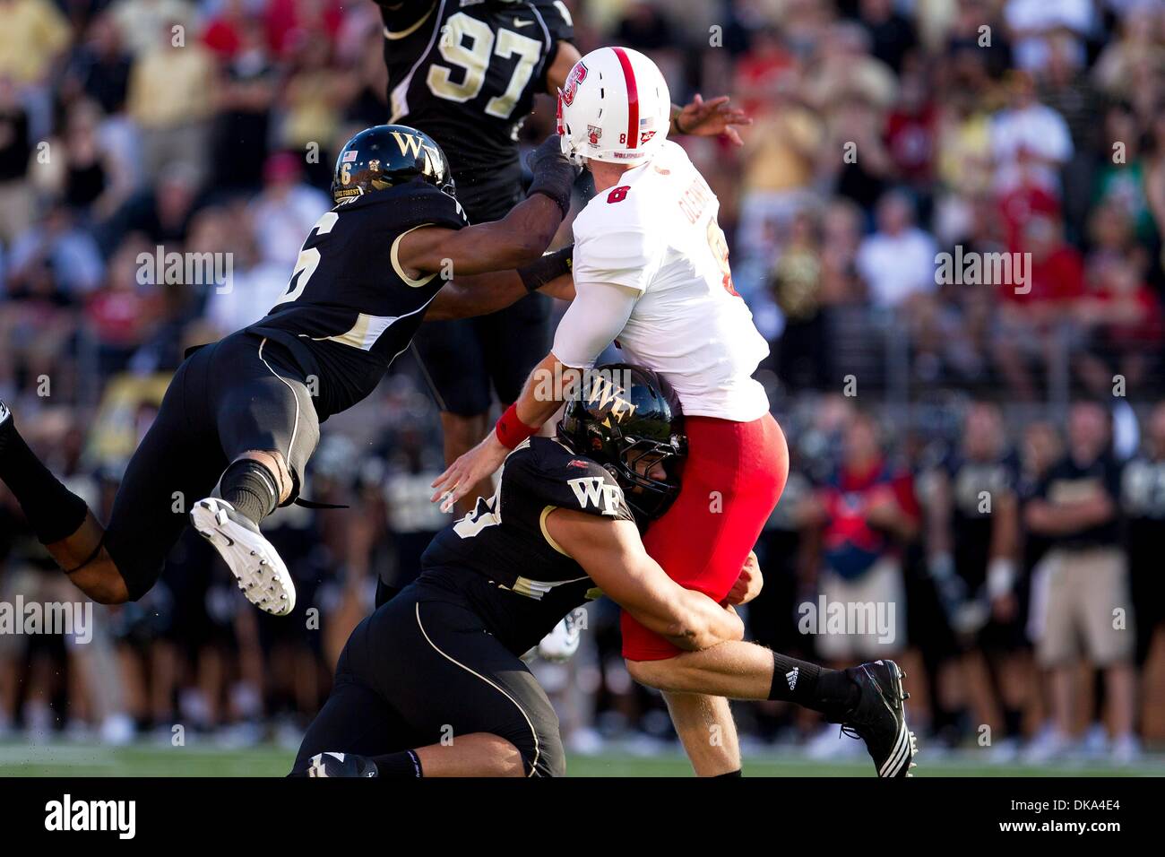 Sept. 10, 2011 - Winston-Salem, North Carolina, U.S - Wake Forest Demon Deacons cornerback Kenny Okoro (6) and North Carolina State Wolfpack linebacker Calvin Forbes (50) hit North Carolina State Wolfpack quarterback Mike Glennon (8) just after a touchdown throw during the Wake Forest vs. NC State football game.  Wake Forest defeats NC State 34-27. (Credit Image: © Tony Brown/South Stock Photo