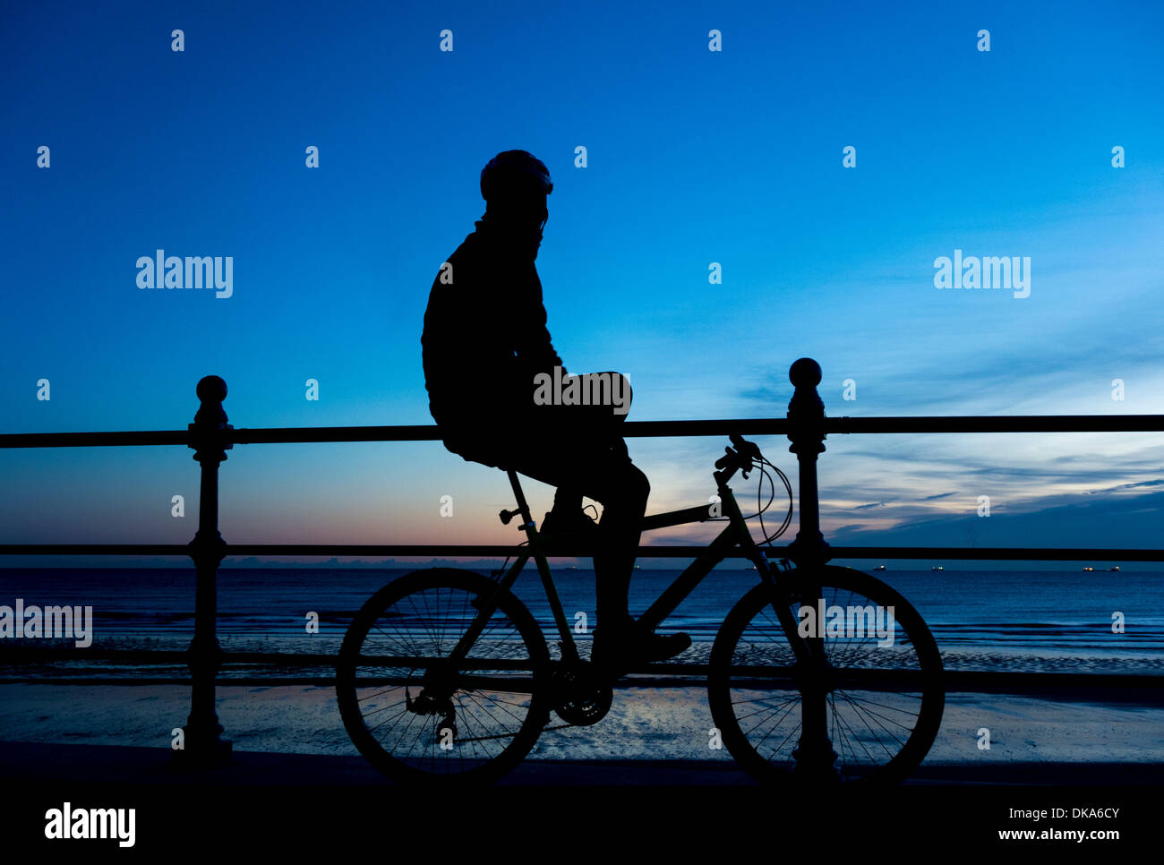 Mountain biker watching sunrise at Seaton Carew beach near Hartlepool, England, UK. Stock Photo