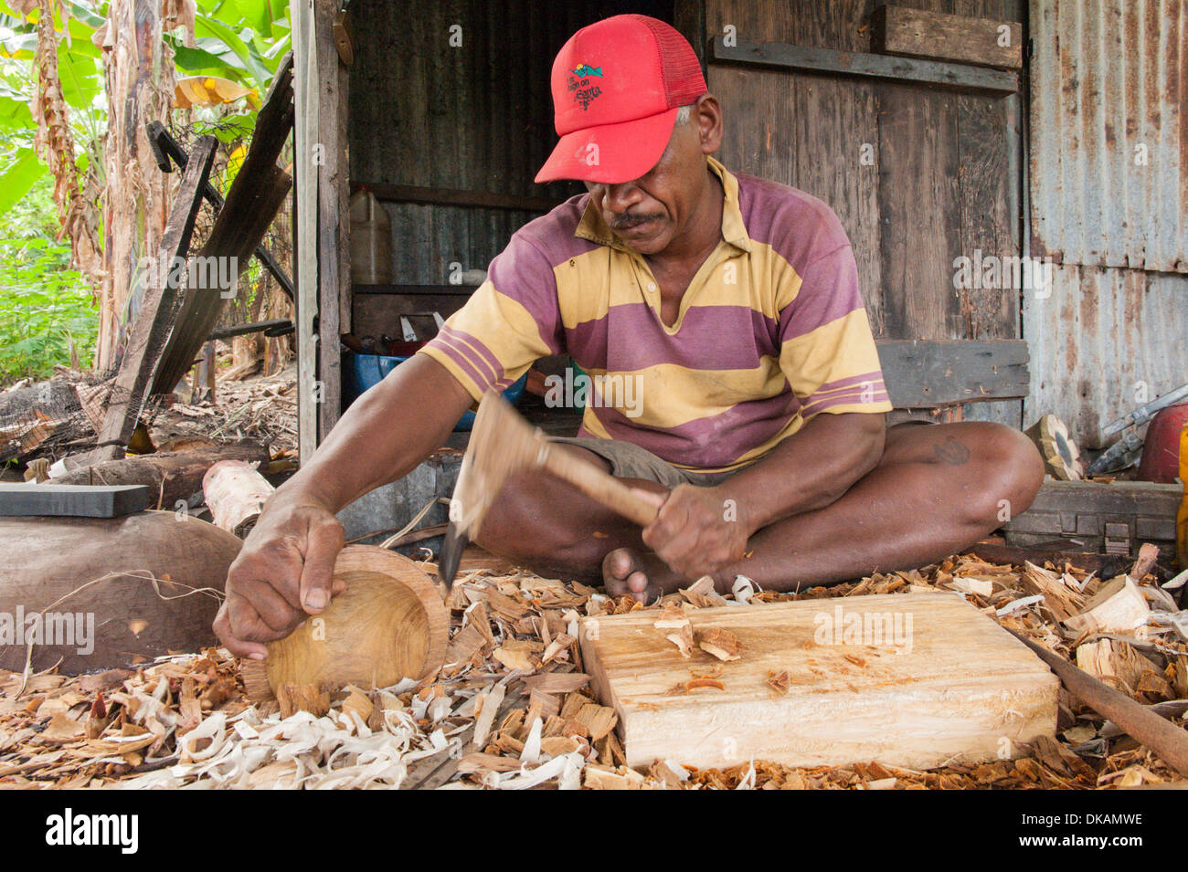 Nico, a wood carver carving tanoa, tradtional kava bowls out of vesi, a local hardwood. Muanaicake village, Fulaga, Laus Islands, Fiji. Stock Photo