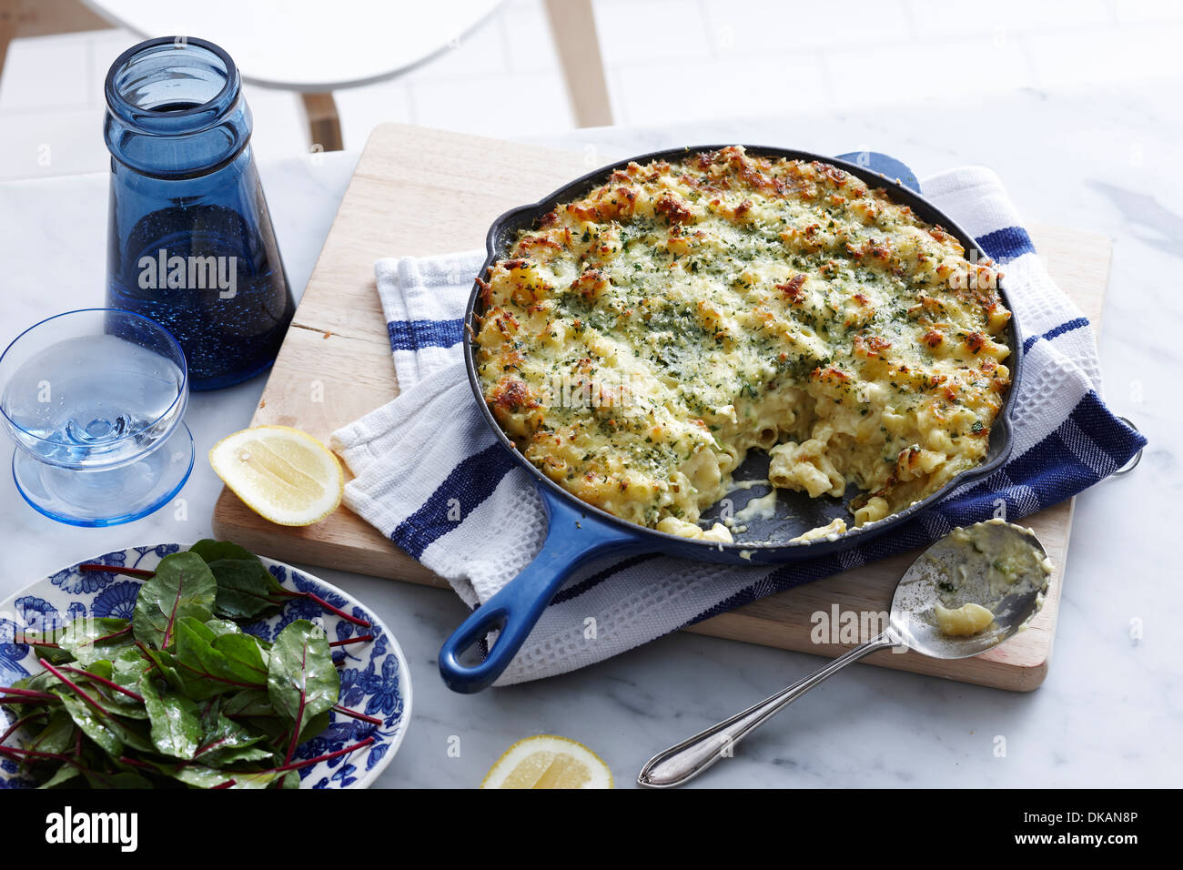 Meal with pan of macaroni cheese and salad leaf Stock Photo