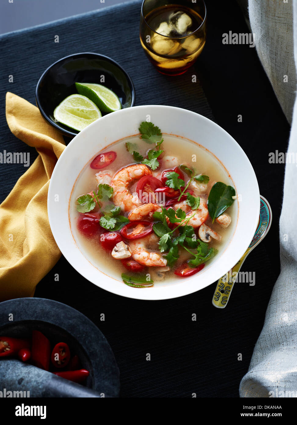 Bowl of Tom yum soup with herb garnish Stock Photo