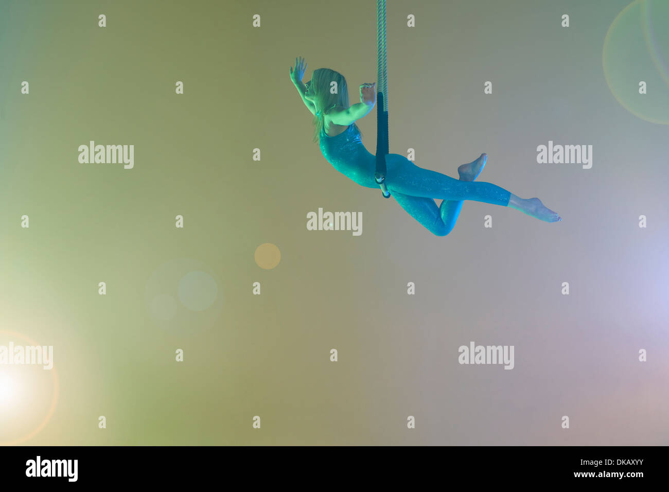 Trapeze artist balancing on trapeze Stock Photo