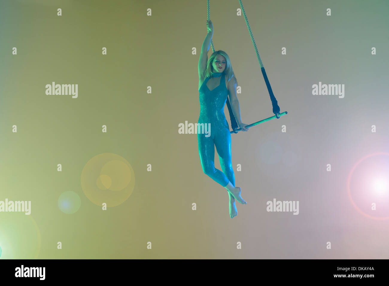 Trapeze artist holding trapeze Stock Photo