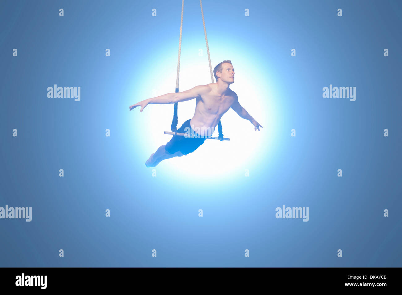 Man balancing on trapeze Stock Photo