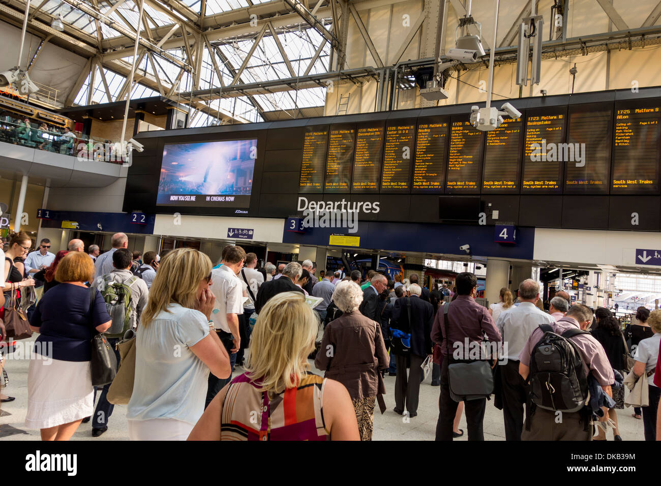 Passengers looking at Departure Information Board, London Waterloo Station Concourse, UK Stock Photo