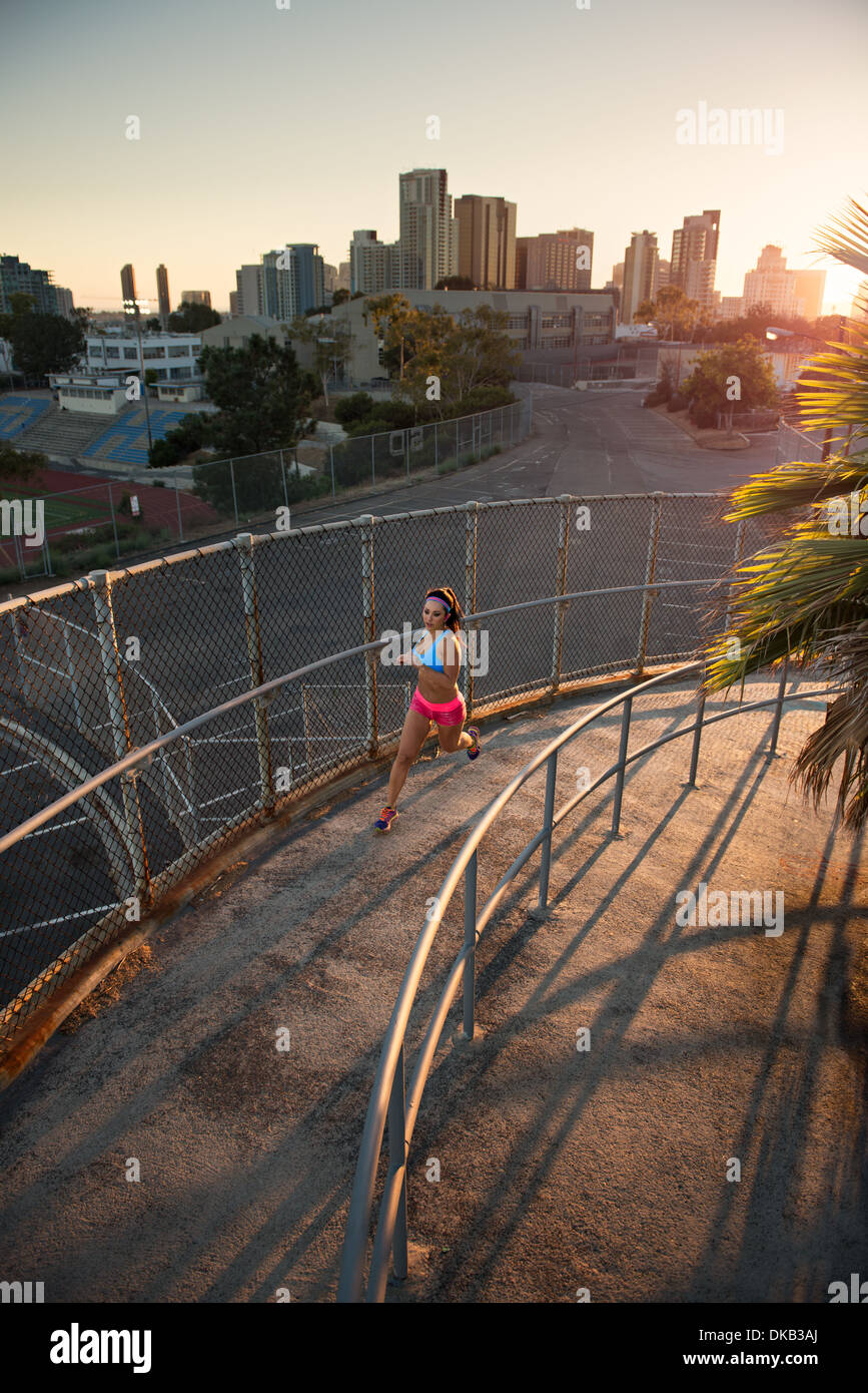 Female athlete running up curved walkway Stock Photo