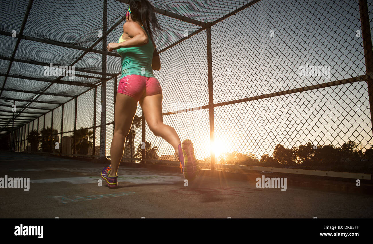 Female athlete running along walkway Stock Photo