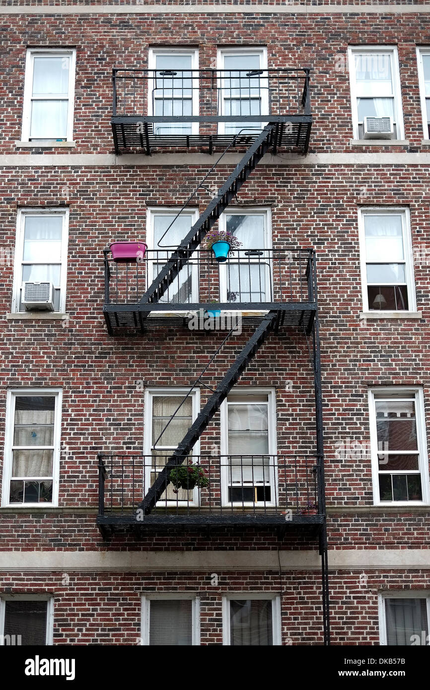 A classic New York City fire escape on the front of an tenement apartment building in Manhattan. Stock Photo