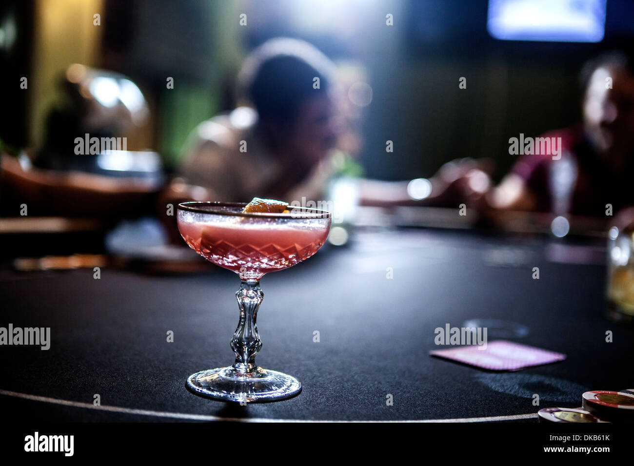 Mid adult men playing poker and drinking cocktails Stock Photo