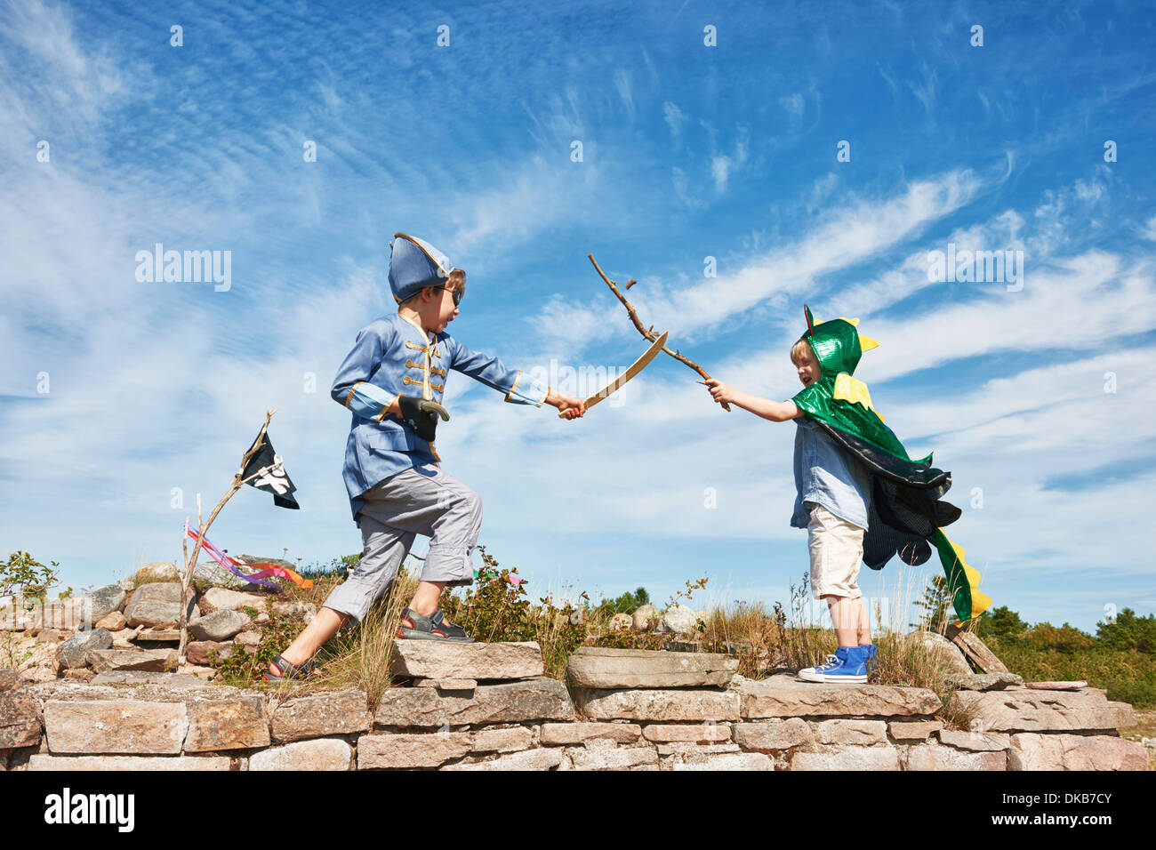 Two boys in fancy dress play fighting with sticks, Eggergrund, Sweden Stock Photo