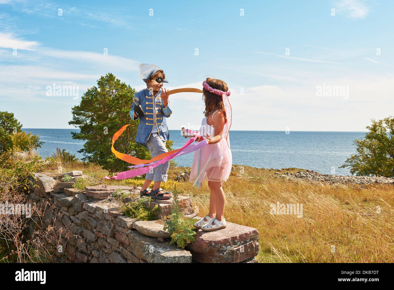Two children in fancy dress holding streamers, Eggergrund, Sweden Stock Photo