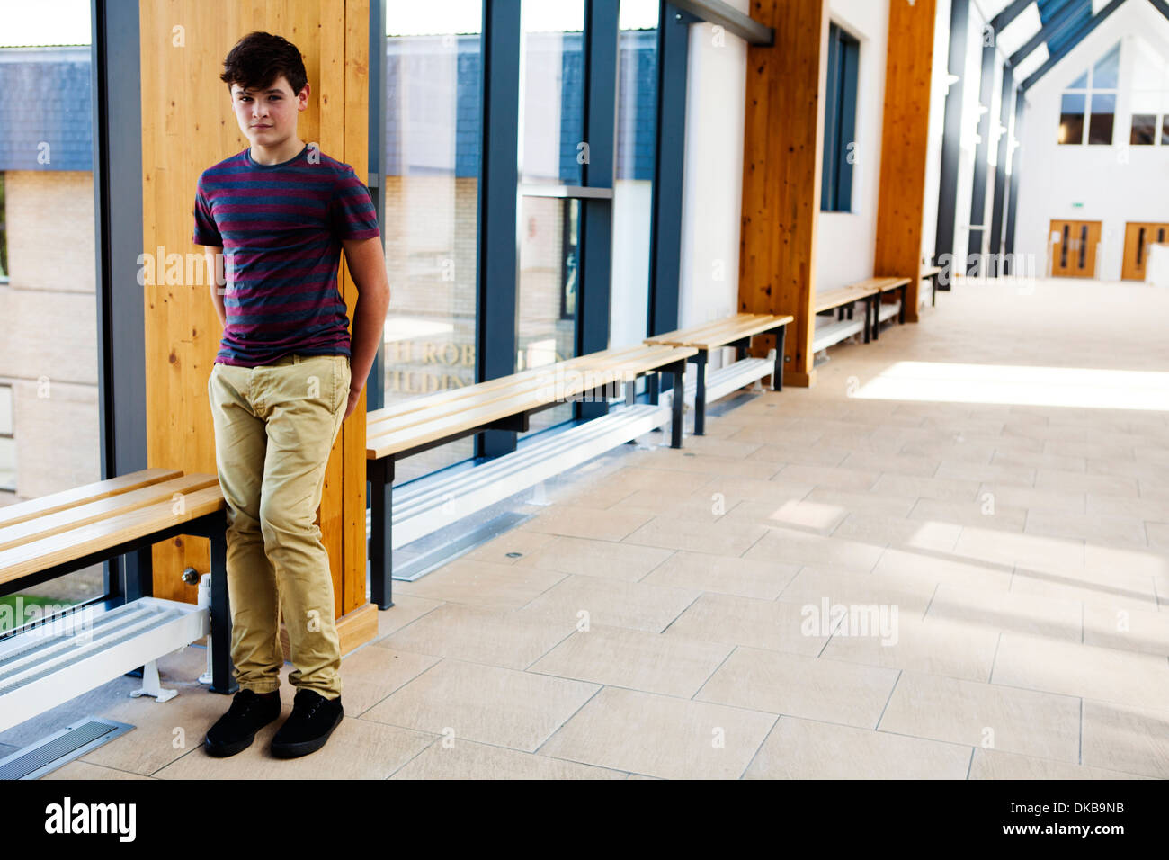 Portrait of isolated teenage schoolboy in corridor Stock Photo