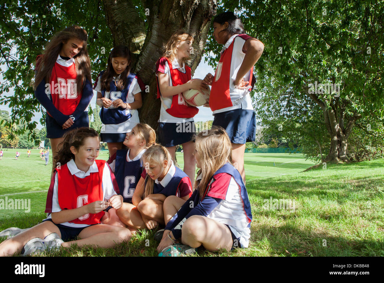 Teenage schoolgirl netball team taking a break Stock Photo