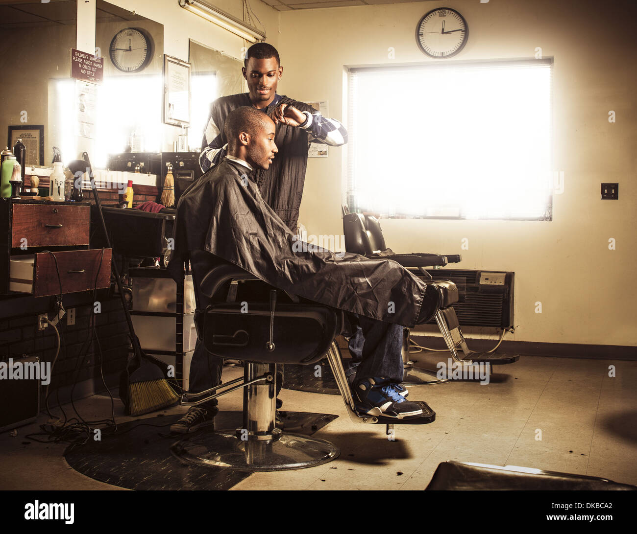 Barber in traditional barber shop shaving man's head Stock Photo