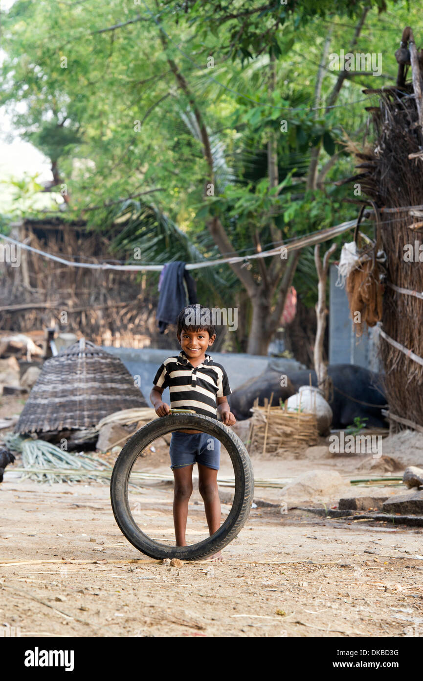 Rural Indian village boy playing with a tyre. Andhra Pradesh, India Stock Photo