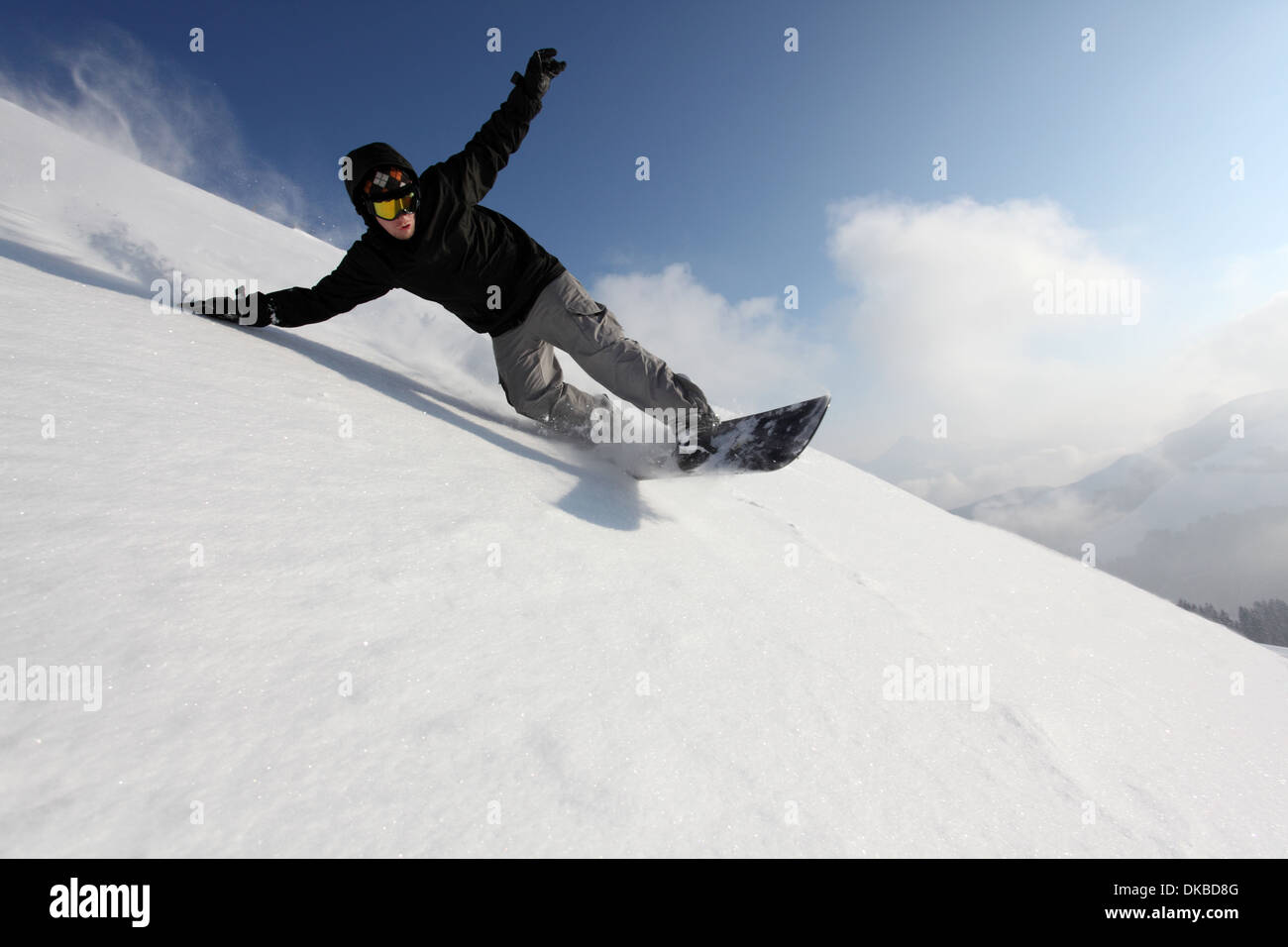 Snowboarder going down mountain Stock Photo