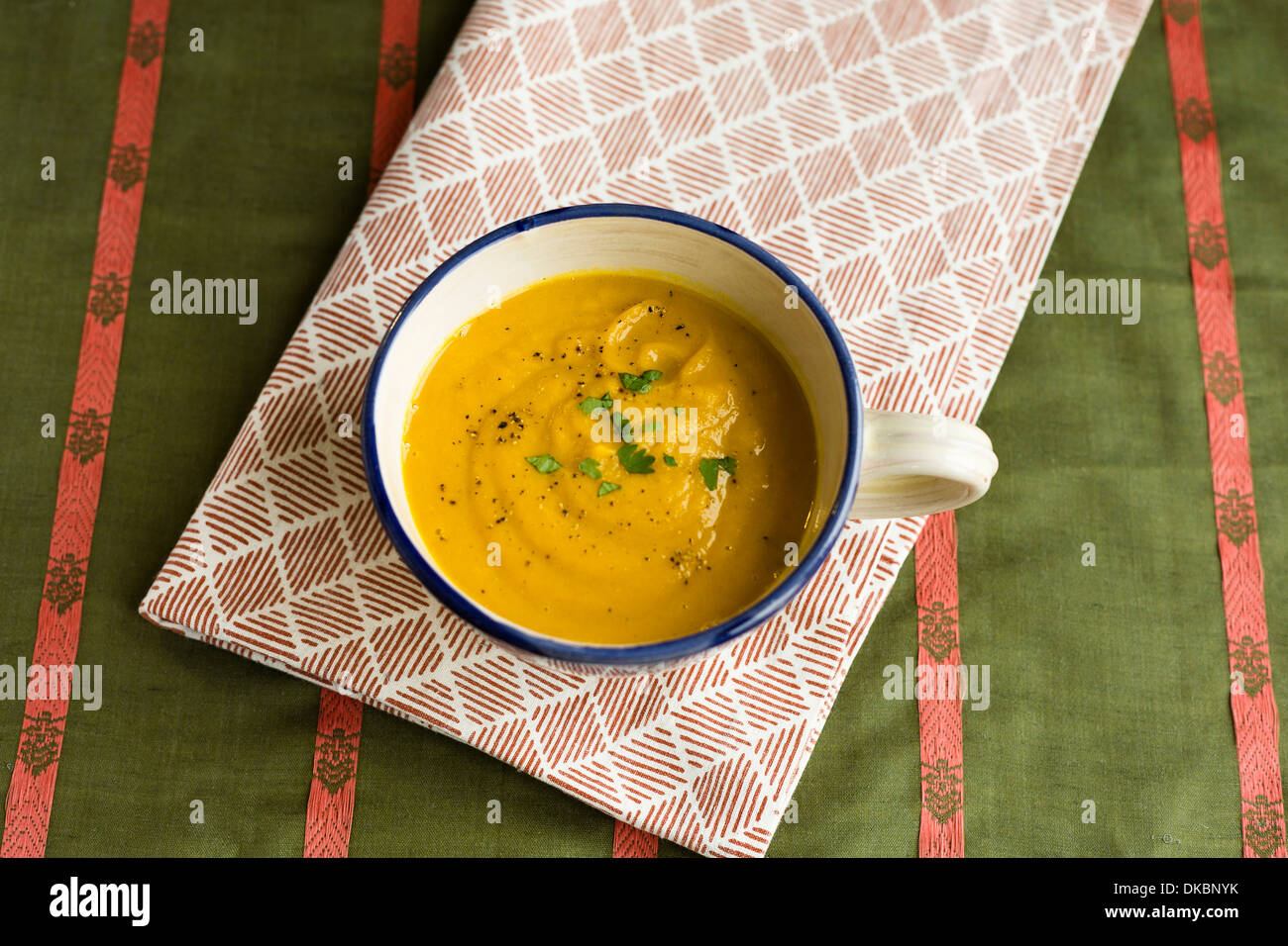 Simple view of winter vegetable carrot and coriander soup, in large mug. Stock Photo