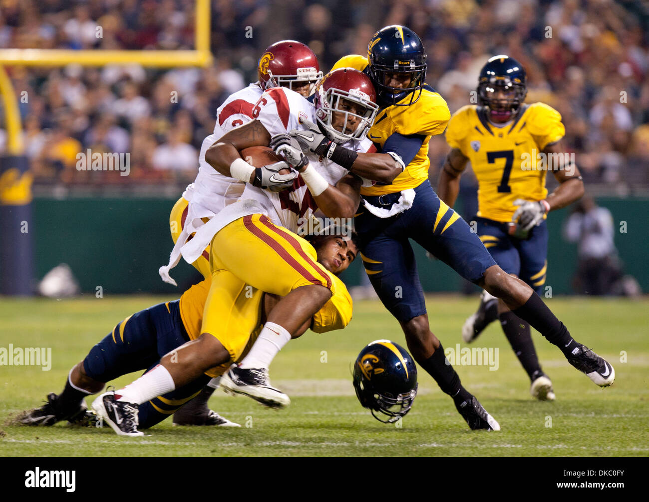 Oct. 13, 2011 - San Francisco, CA, USA - Cal's Mychal Kendricks gets his helmet knocked off as he and Cal's Stefan McClure work to take down USC's Marc Tyler. Cal vs USC football at AT & T Park Thursday Oct. 13, 2011. Marty Bicek/ZumaPress.com (Credit Image: © Marty Bicek/ZUMAPRESS.com) Stock Photo