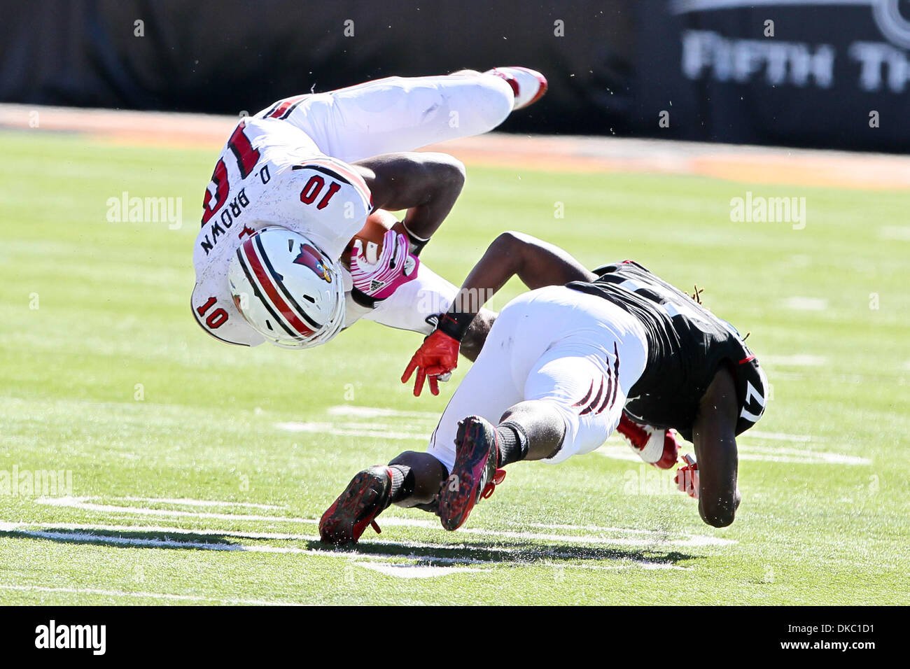 Oct. 15, 2011 - Cincinnati, Ohio, U.S. - Cincinnati Bearcats defensive back CAMERRON CHEATHAM (21) upends Louisville Cardinals quarterback DOMINIQUE BROWN (10) in game action during the Big East football game. (Credit Image: © Jon Longo/Southcreek/ZUMAPRESS.com) Stock Photo