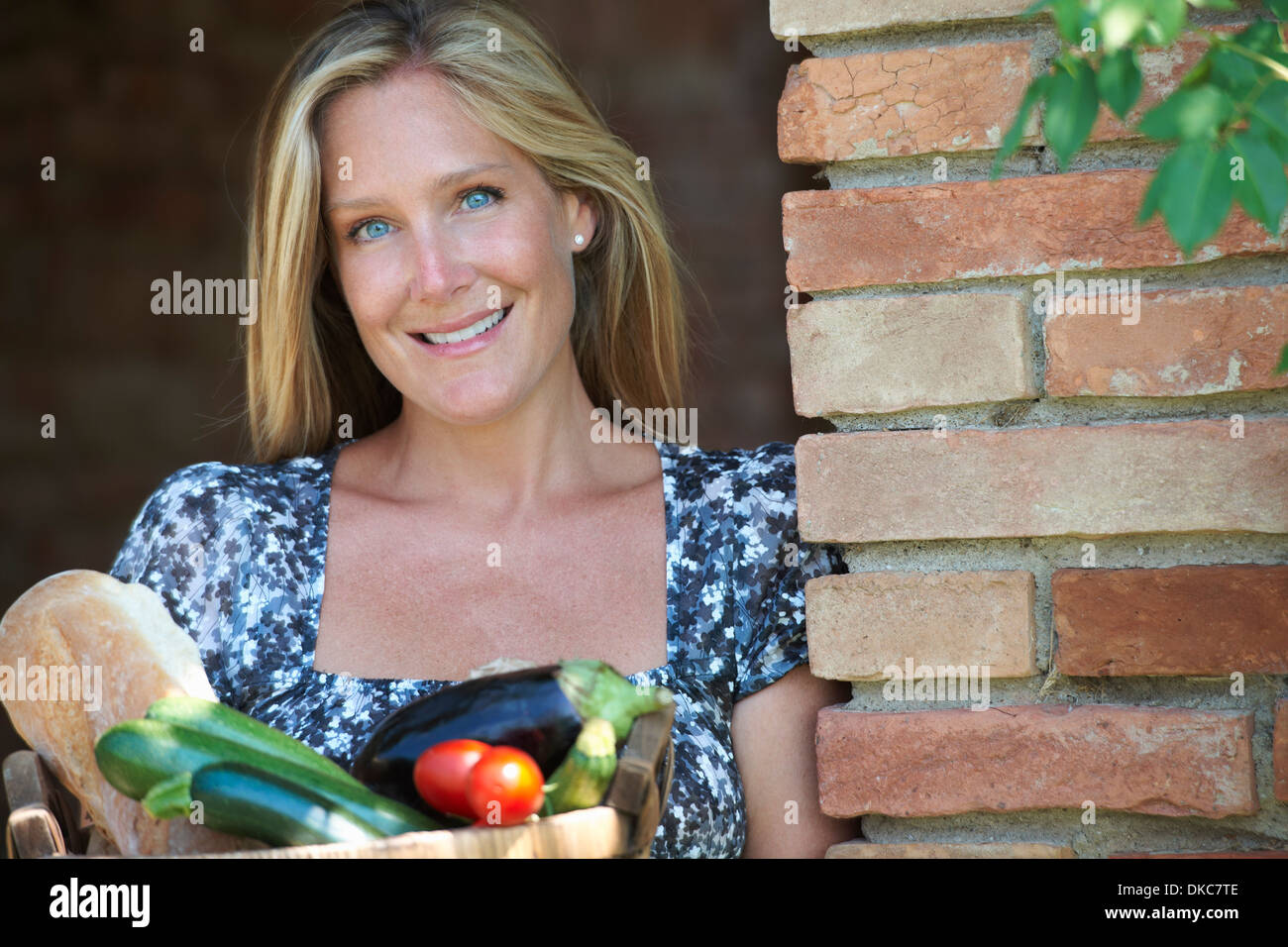Mature woman standing outside with basket of organic food Stock Photo