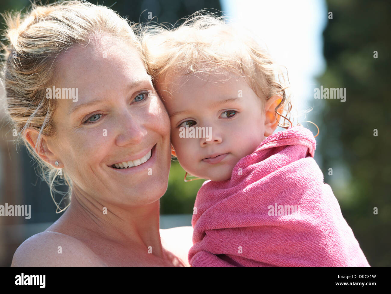 Mother holding toddler wrapped in towel Stock Photo