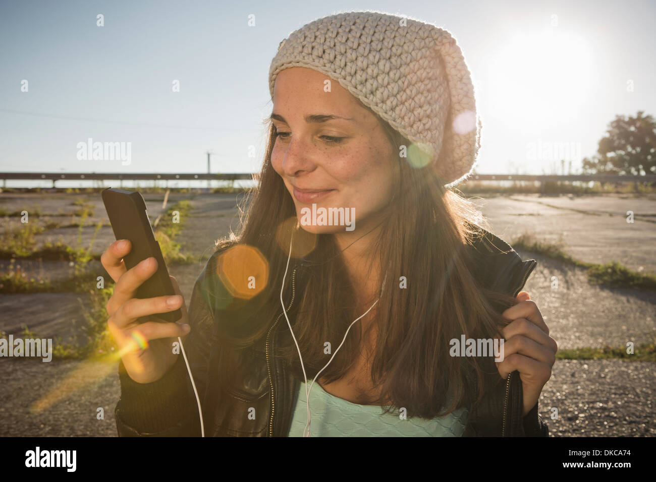 Young woman wearing earphones listening to music Stock Photo Alamy