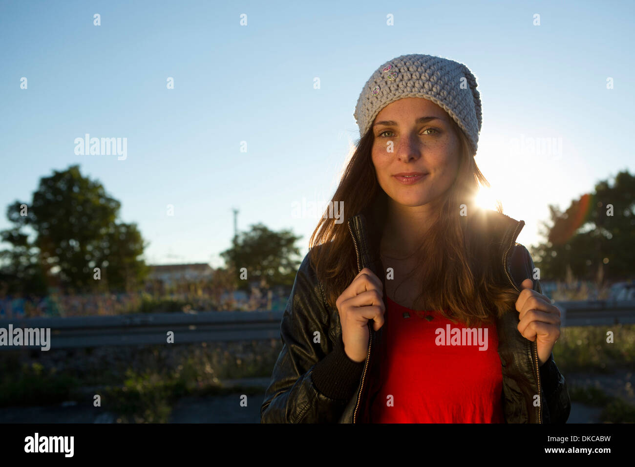 Portrait of young woman in leather jacket and beanie Stock Photo - Alamy