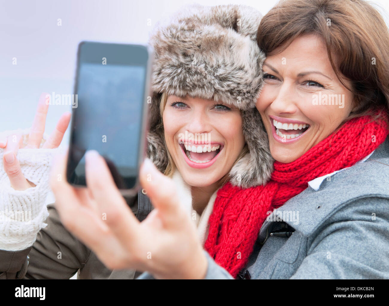 Two female friends taking self portrait at coast, Thurlestone, Devon, UK Stock Photo