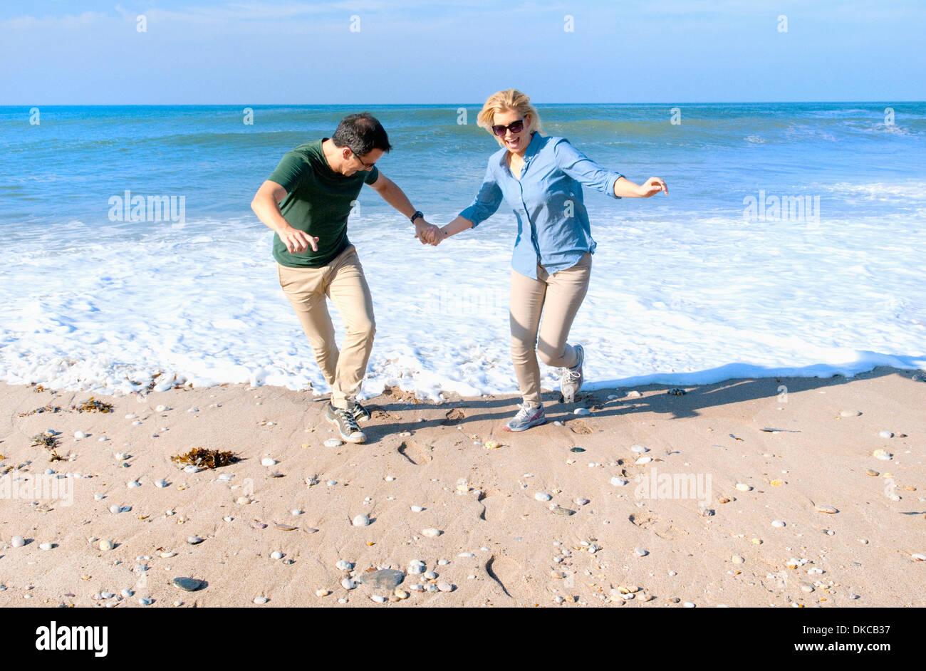 Mid adult couple fooling around on beach, Thurlestone, Devon, UK Stock Photo