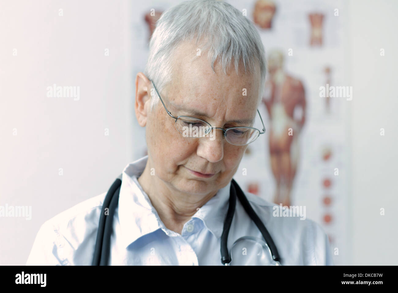 a laughing  woman doc with a human muscle person poster in the background Stock Photo