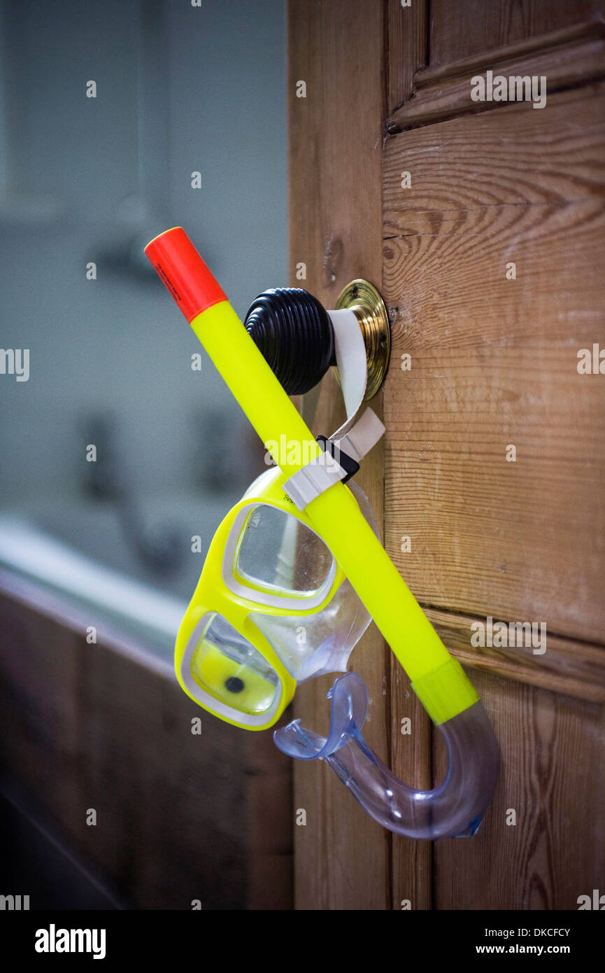 Open bathroom door with hanging snorkel and goggles Stock Photo