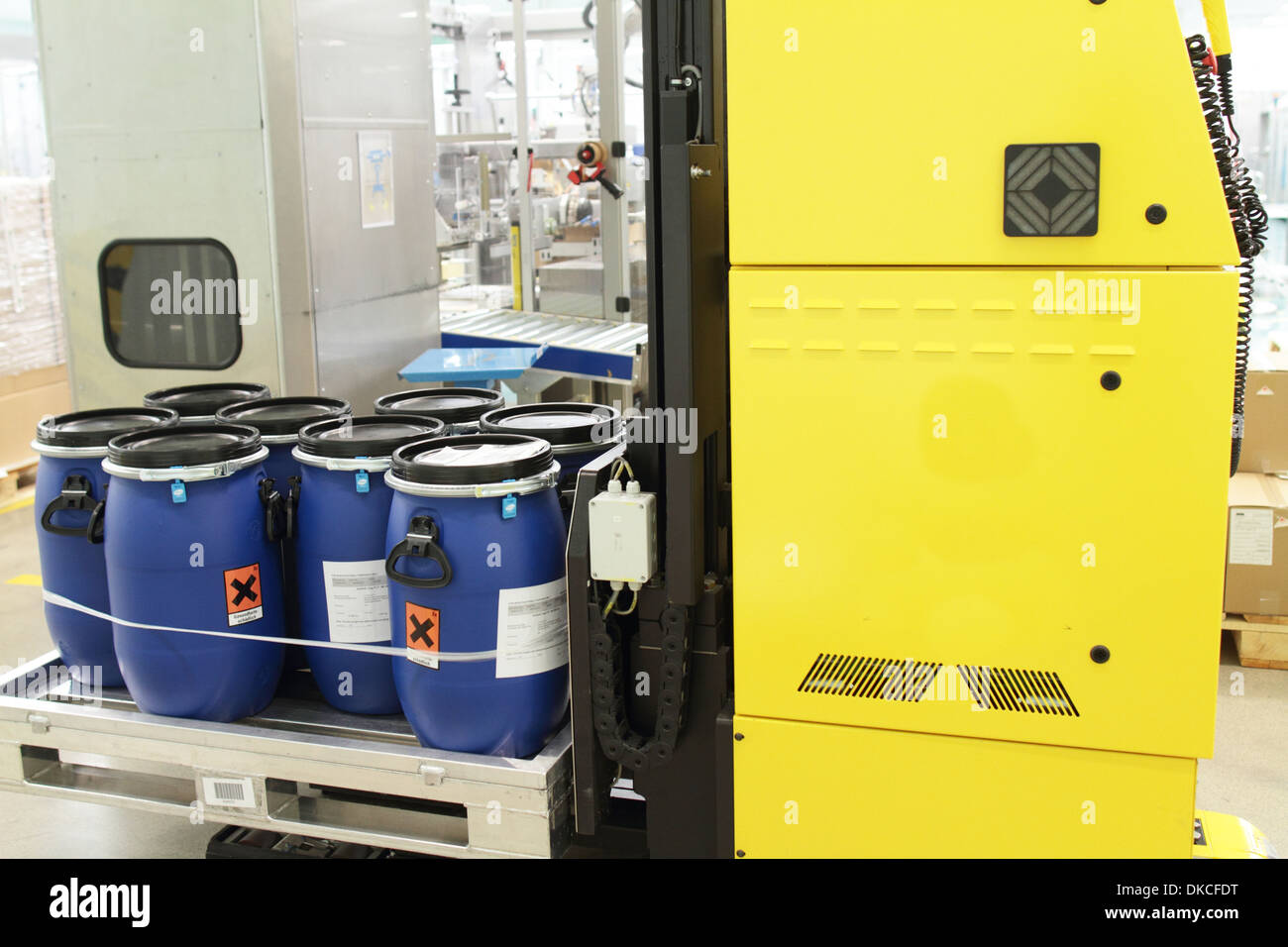 A self-acting fourwheel lifting truck carrying barrels with chemicals in an industrial hall of pharmacy. Stock Photo