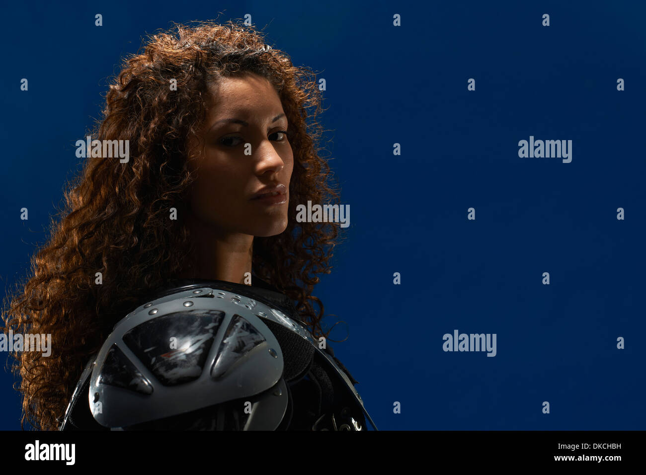 Portrait of young woman wearing american football shoulder pads Stock Photo