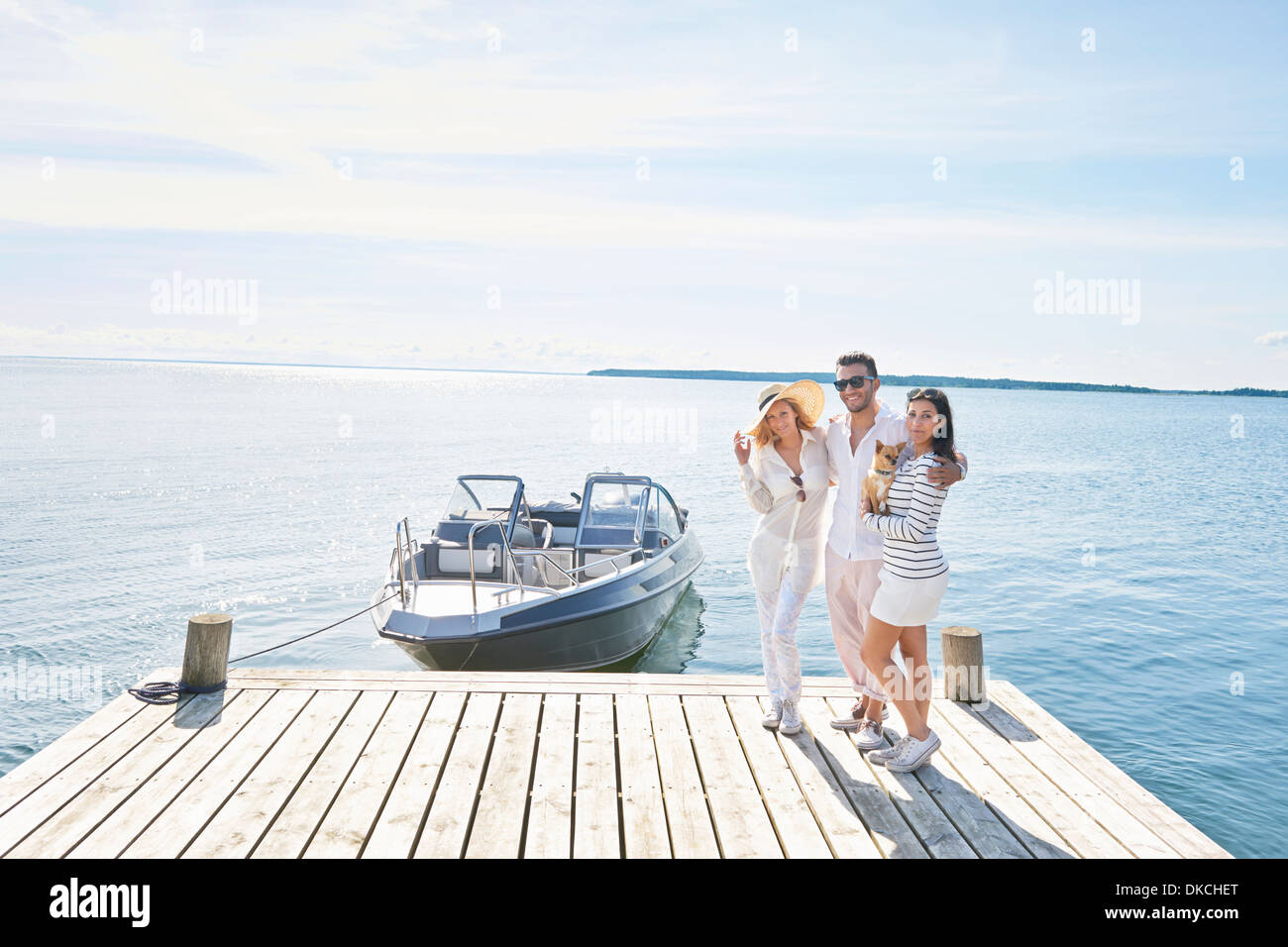 Young adults on pier with boat, Gavle, Sweden Stock Photo