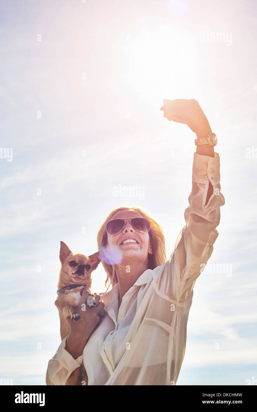 Young woman photographing herself with dog Stock Photo