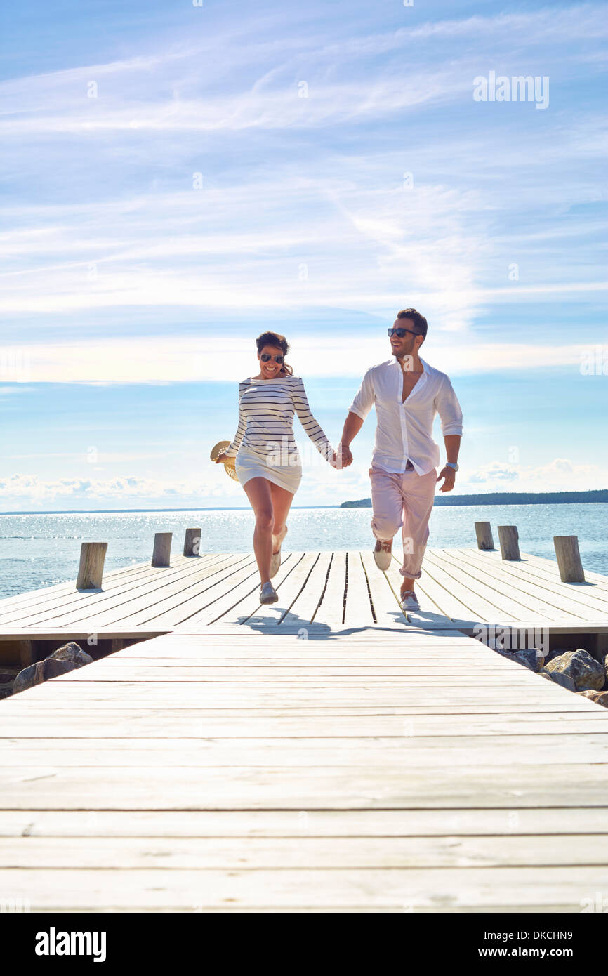 Young couple holding hands on pier, Gavle, Sweden Stock Photo